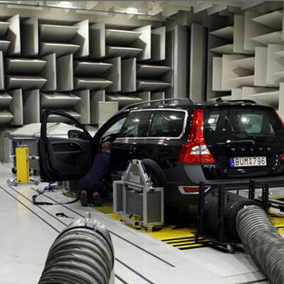 "Car being tested in anechoic chamber for sound quality assessment."