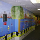 Colorful mural depicting a waterfront scene in a hospital hallway.