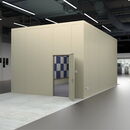 Modern industrial space with beige partition, open door, and electrical panels.