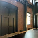 Modern industrial interior with black doors and exposed brick walls.