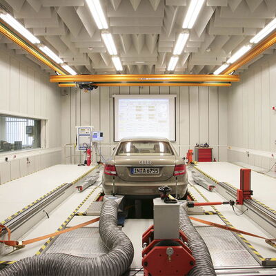 Car testing facility with monitoring equipment and exhaust systems for emissions analysis.