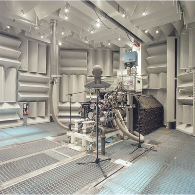 Engine testing facility with acoustic panels and monitoring equipment in a controlled environment.