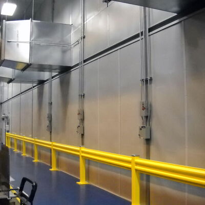 Industrial interior with yellow safety railing and ventilation ducts.