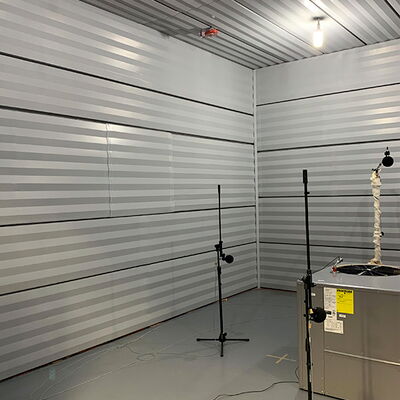 Acoustic treatment room with microphones for sound testing and recording.