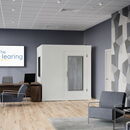 Modern hearing center interior with examination booth and contemporary furnishings.