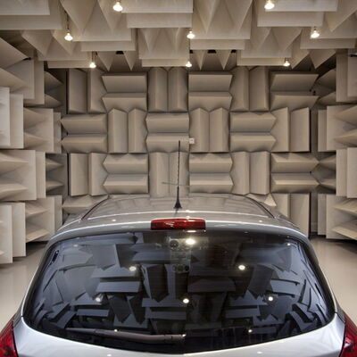 "Car in an anechoic chamber with acoustic panels for sound testing."