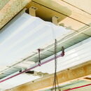 Translucent ceiling panels with exposed beams and pipes in industrial setting.